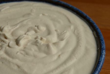 Blue pottery bowl of creamy fermented cashew yoghurt