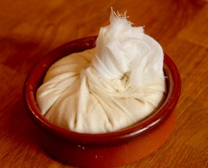 Creamy cashew cheese, pressed into a terracotta bowl.