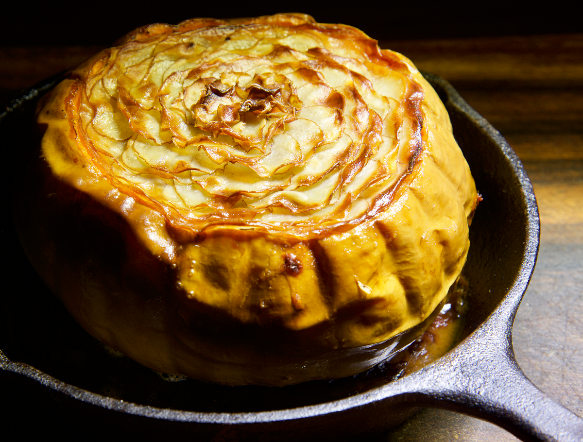 Layered baked butter kin topped with crispy potato rosette