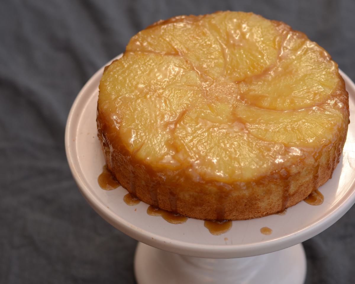 Pineapple upside down cake with rum caramel on a cake stand
