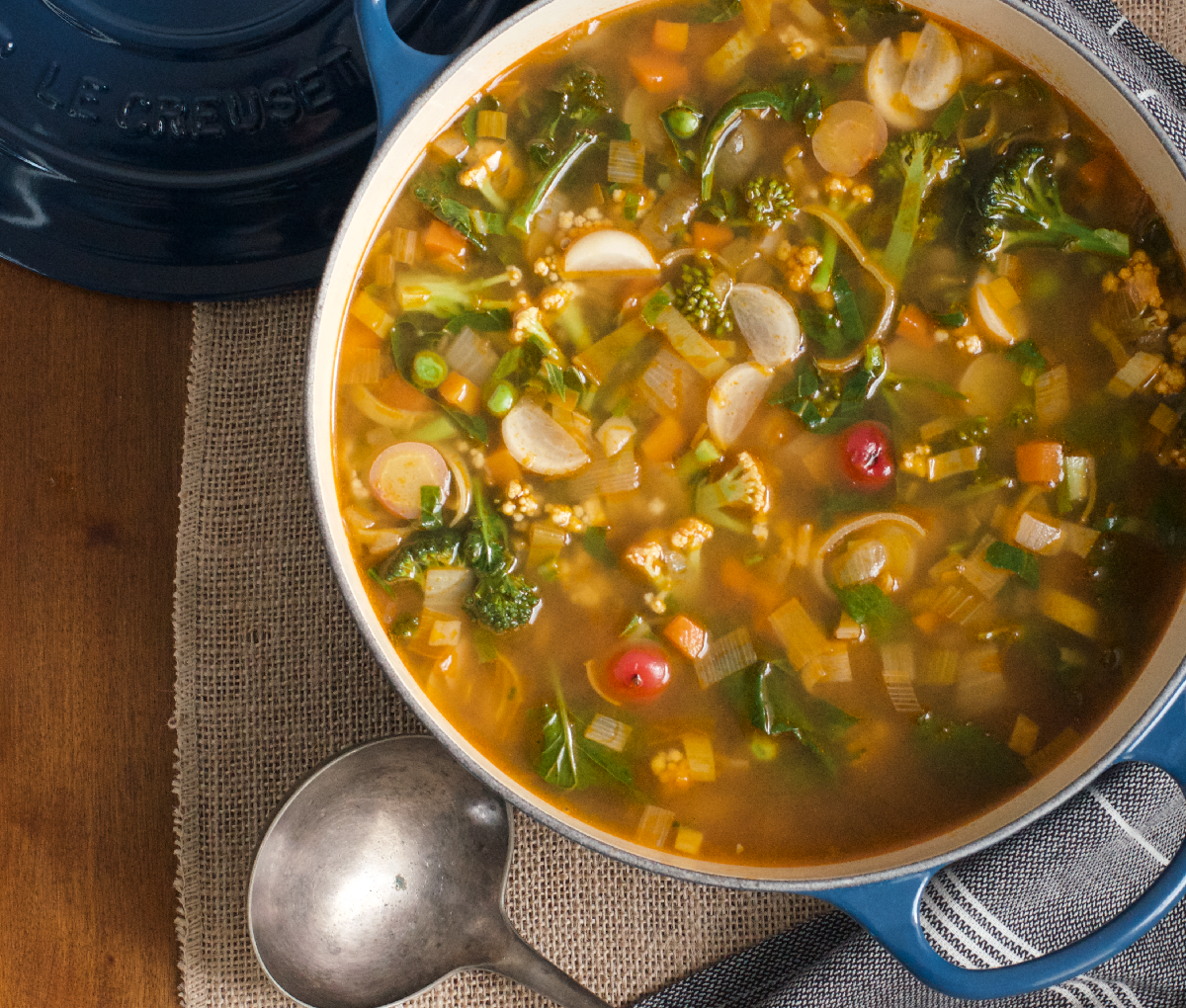 Large pot of winter garden soup full of colourful chopped vegetables,