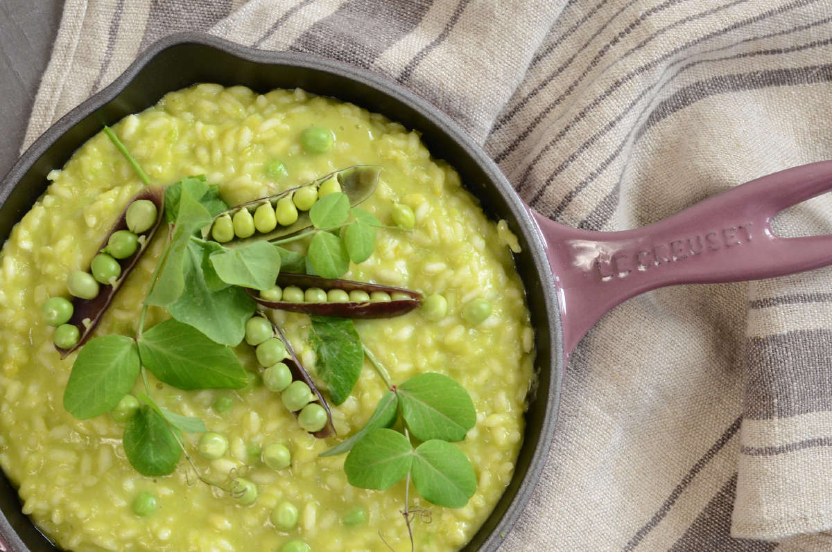 Cast iron pan with bright green pea risotto
