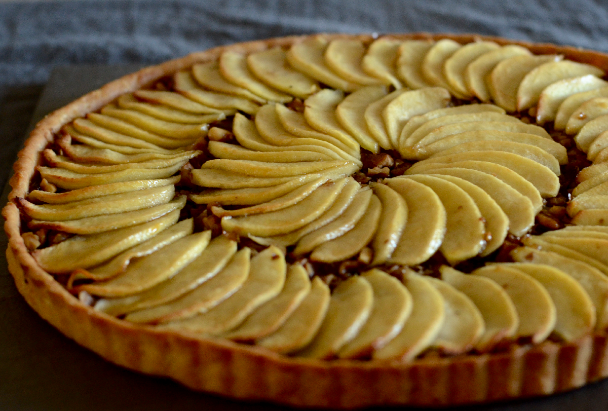 A plant-based apple tart with thin slices of glazed baked apples arranged on 2 circles