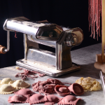 A pasta machine and fresh plain and coloured pasta