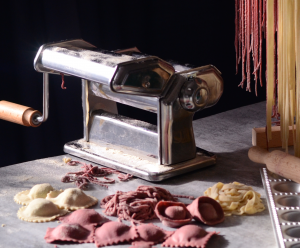 A pasta machine and fresh plain and coloured pasta